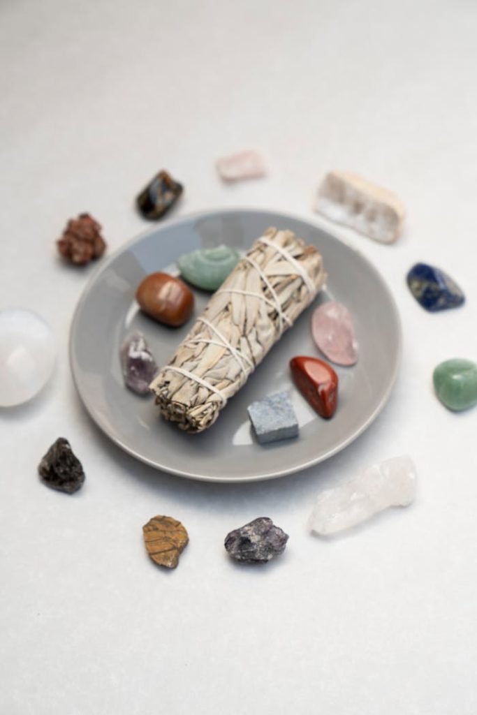 Flat lay of sage bundle and healing crystals for spiritual rituals on a plate, ideal for mindfulness and energy cleansing.